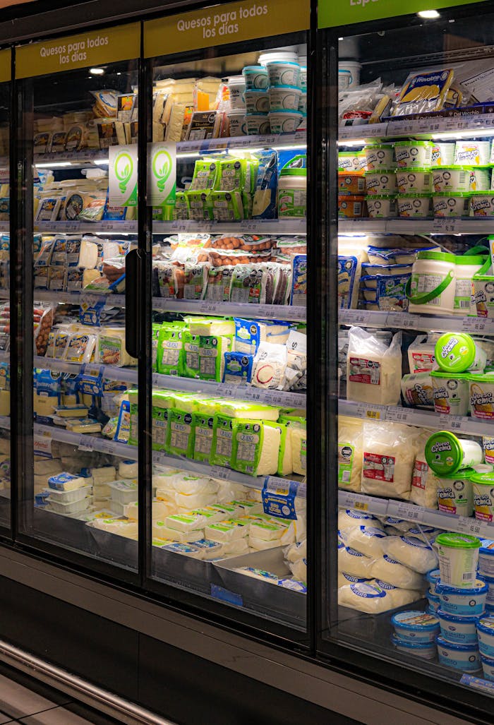 A wide selection of dairy and plant-based products in a supermarket refrigerated section.